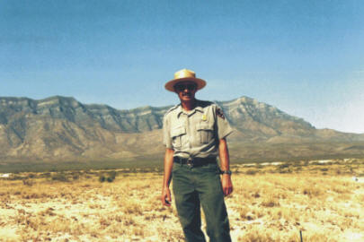 A Ranger in front of mountain range surrounding White Sands National Monument - Lake Lucero
